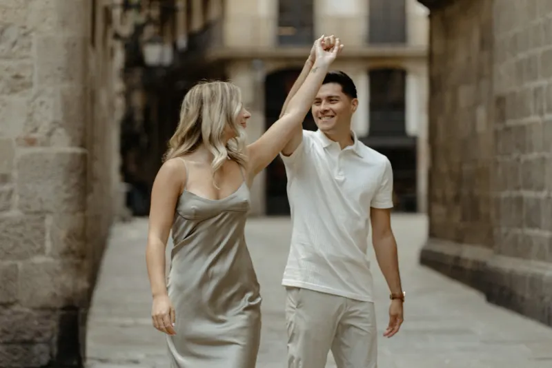 Couple dancing together in a quiet Barcelona alley, sharing a joyful moment during a Vacation Portraits photoshoot.