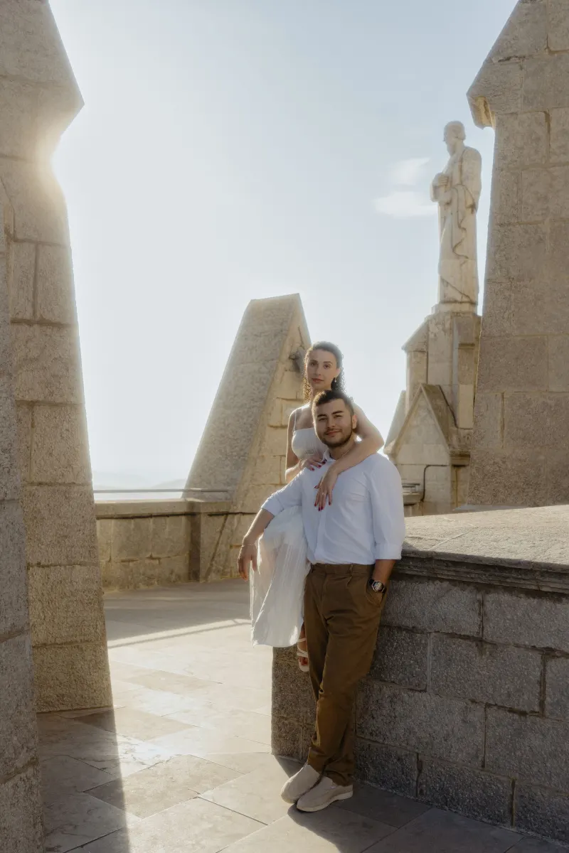 Couple embraces on a sunlit stone terrace, sharing a serene moment during their couples & engagements photoshoot.