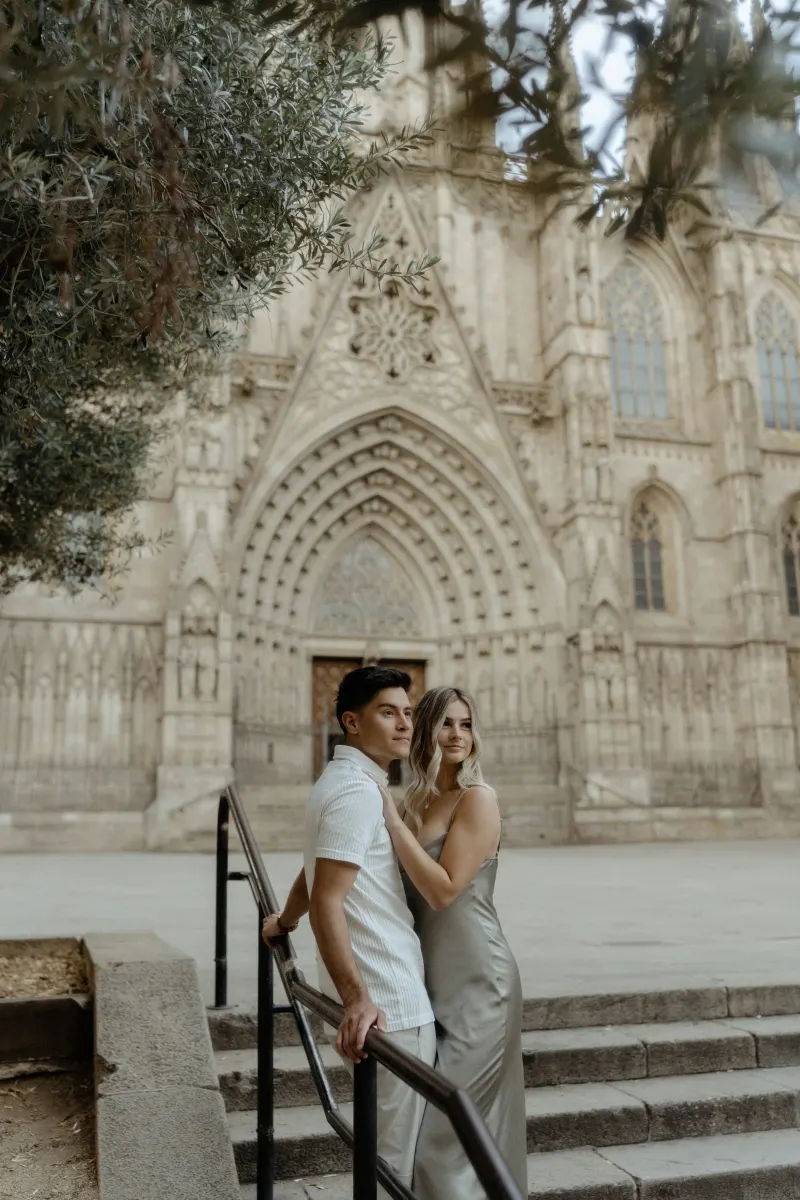 Couple embracing on cathedral steps in Barcelona, captured during a Vacation Portraits photoshoot.