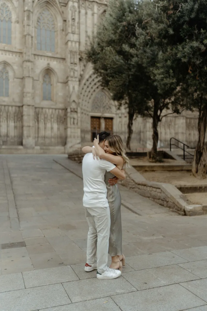 Couple embracing warmly outside Barcelona’s cathedral, captured during a Vacation Portraits photoshoot.