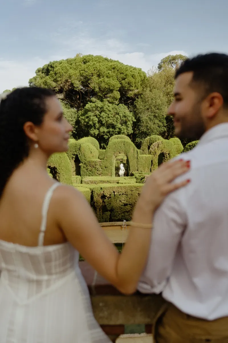 Couple enjoys a peaceful moment overlooking a lush garden maze during their couples & engagements photoshoot.