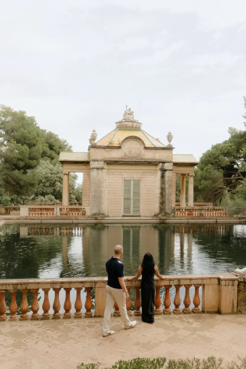 Couple enjoys a quiet, romantic moment by a historic garden pond during a surprise proposal photoshoot.