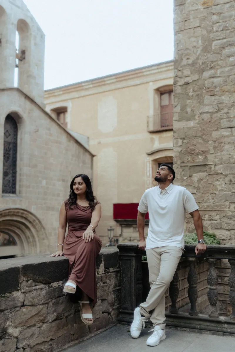 Couple enjoys a relaxed moment together in a historic courtyard during their couples & engagements photoshoot.