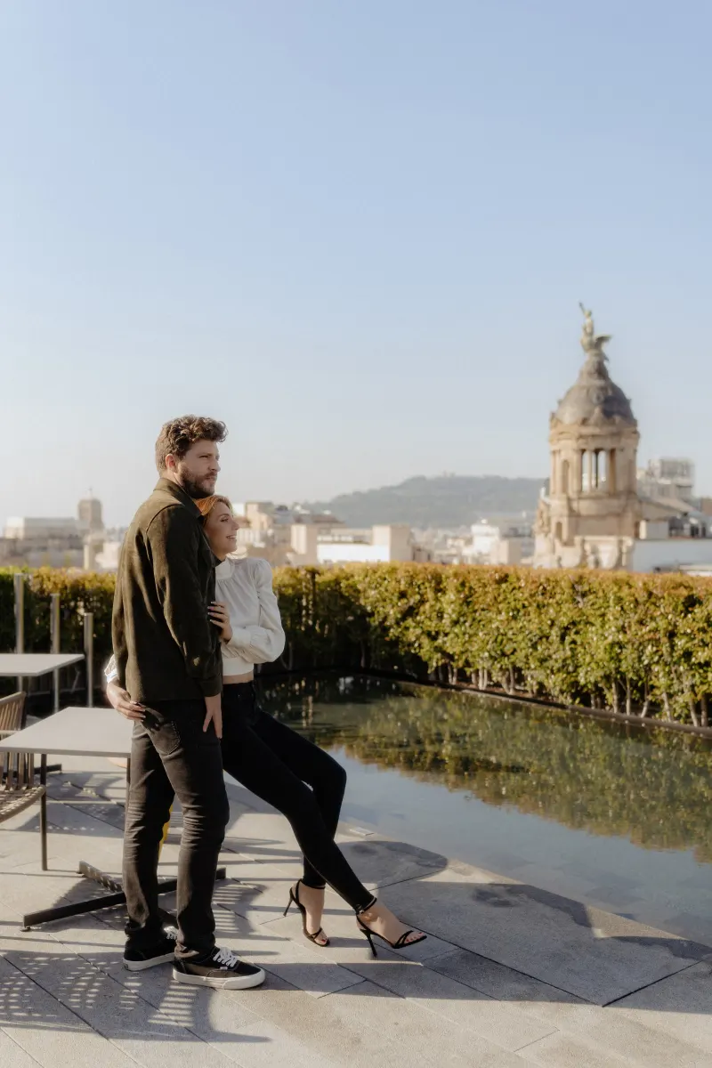 Couple enjoys a relaxed rooftop moment by the water, captured during a couples & engagements photoshoot in the city.
