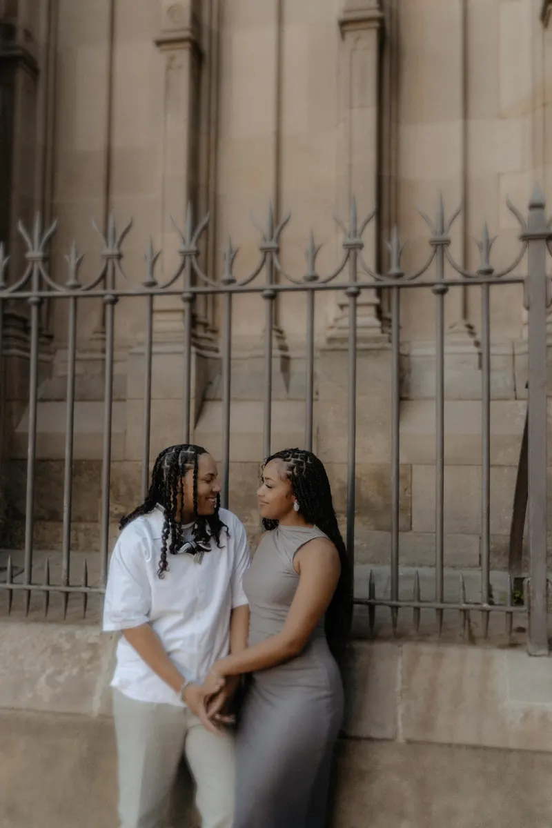 Couple gazes at each other and holds hands, sharing a quiet, heartfelt moment during a surprise proposal in Barcelona.