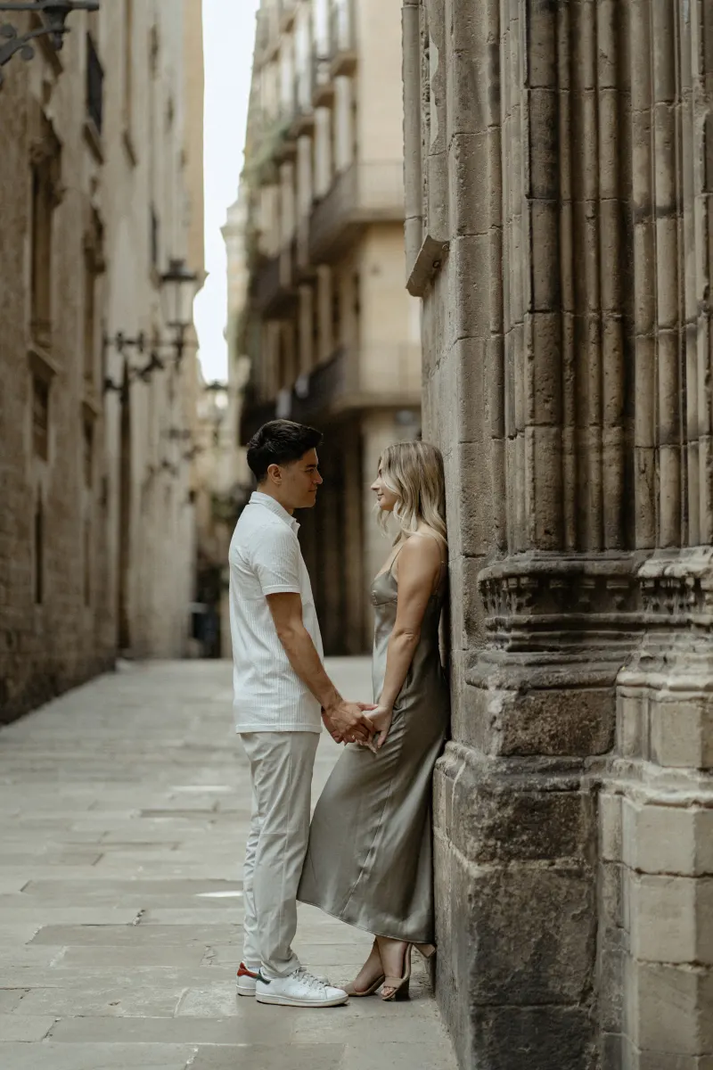 Couple gazing at each other and holding hands in Barcelona’s Gothic Quarter during a Vacation Portraits photoshoot.