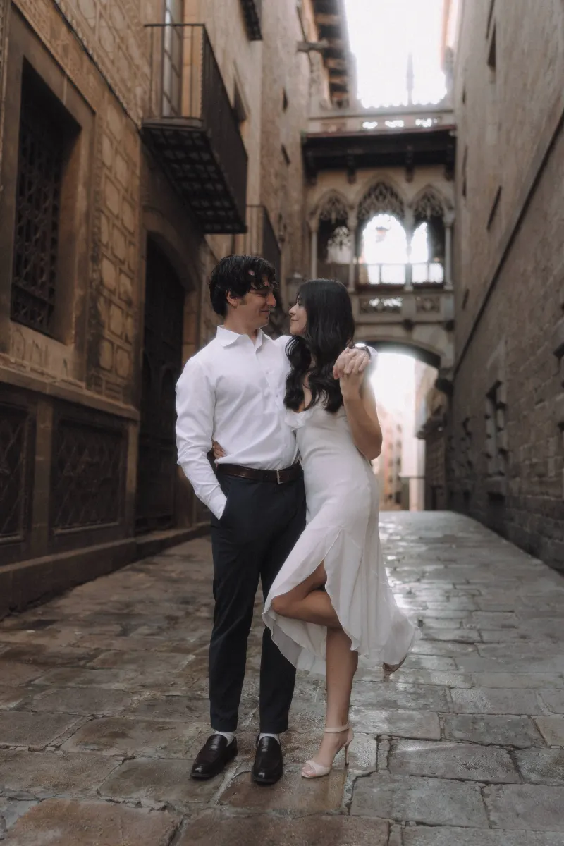 Couple gazing lovingly at each other on a cobblestone street in Barcelona’s Gothic Quarter during an engagement photoshoot.