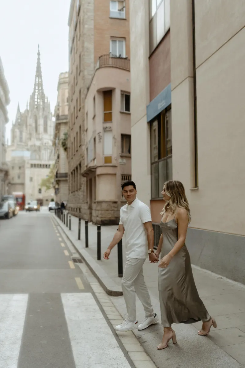 Couple holding hands and smiling while strolling through Barcelona’s Gothic Quarter, captured during a Vacation Portraits pho