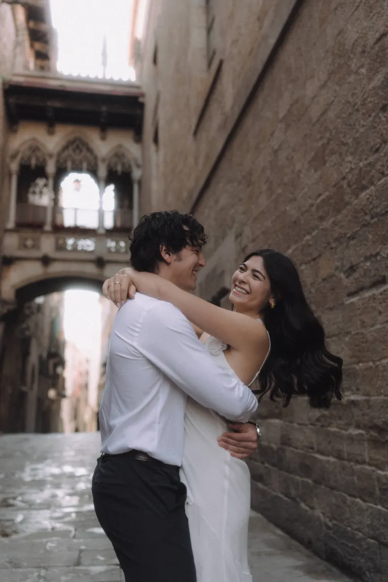 Couple laughing and embracing in a romantic moment during a couples & engagements photoshoot in Barcelona’s Gothic Quarter.