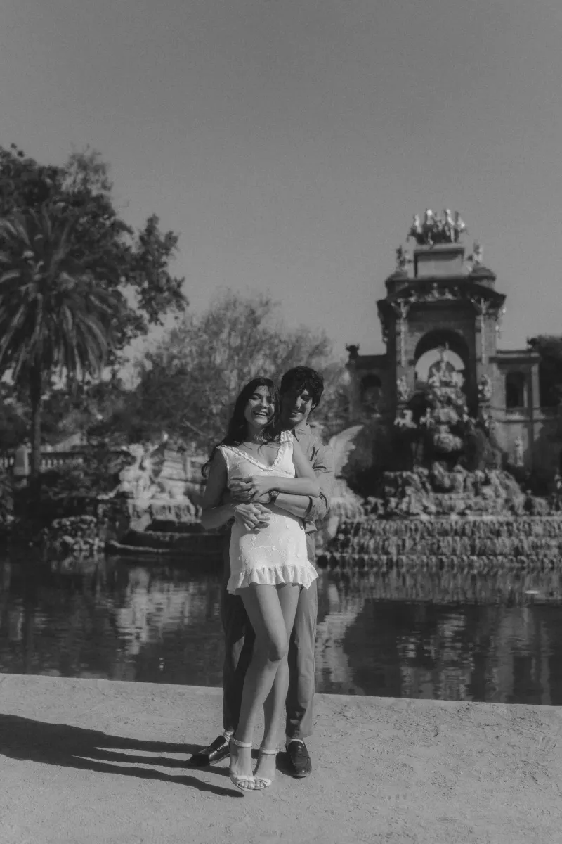 Couple laughing together by the fountain at Parc de la Ciutadella during a joyful couples & engagements photoshoot.
