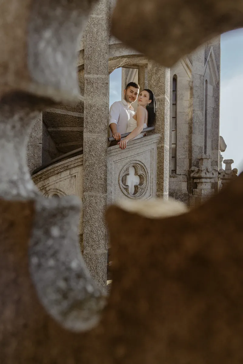Couple leans together on a stone balcony, sharing a quiet moment during their couples & engagements photoshoot.