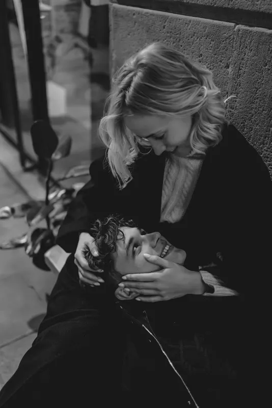 Couple shares a cozy, joyful moment as he rests his head in her lap during a couples & engagements shoot in Barcelona.