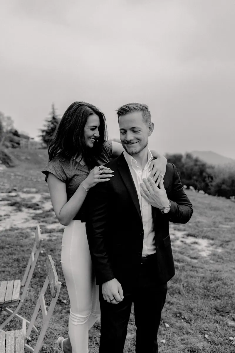 Couple shares a joyful, candid moment outdoors after their countryside surprise proposal photoshoot.