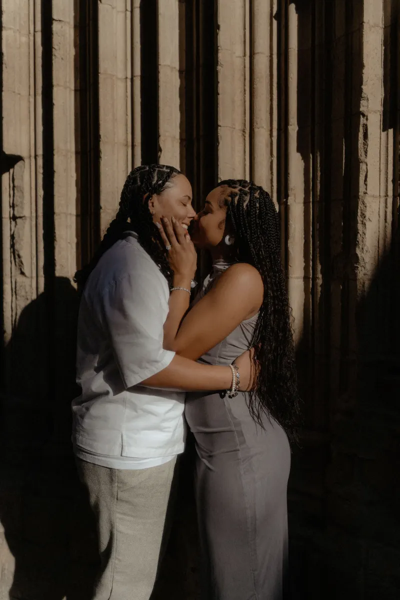 Couple shares a joyful kiss in the golden light of Barcelona’s Gothic Quarter during a surprise proposal photoshoot.