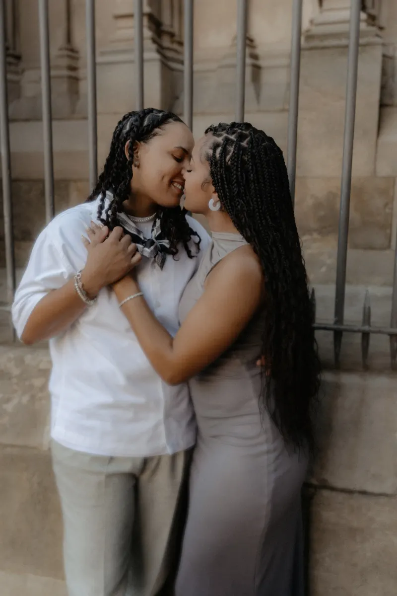 Couple shares a joyful kiss outside Barcelona Cathedral, celebrating their engagement during a surprise proposal photoshoot.
