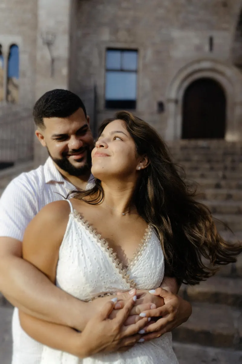 Couple shares a loving embrace on historic stone steps, captured during a couples & engagements photoshoot.