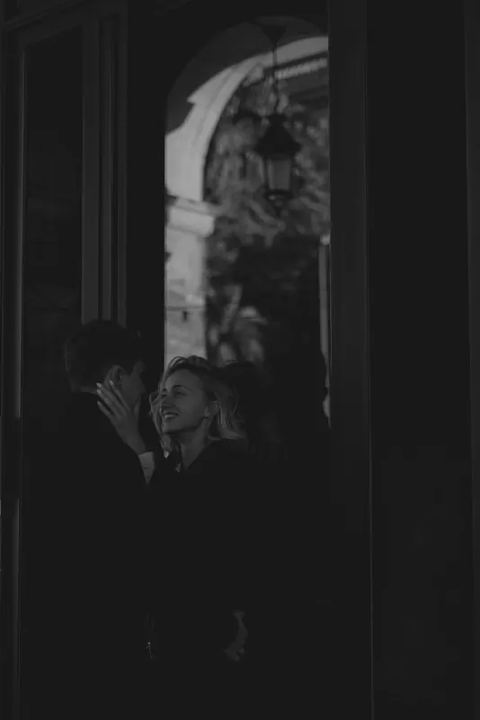 Couple shares a loving gaze in soft window light during a couples & engagements photoshoot in Barcelona.