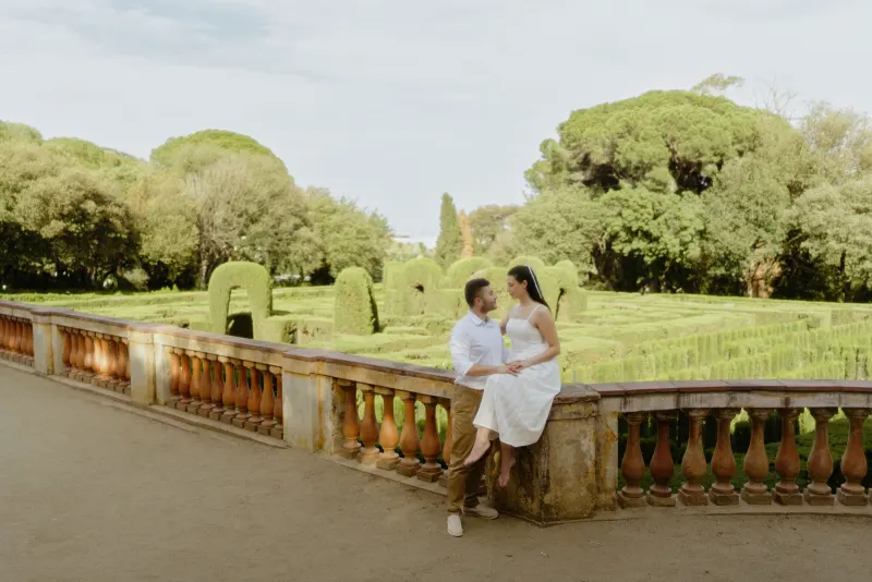 Couple shares a loving gaze on a garden terrace, surrounded by lush greenery during a couples & engagements photoshoot.