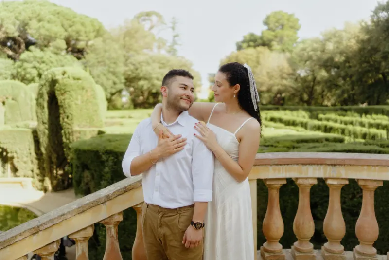Couple shares a loving gaze on a sunlit garden terrace, captured during a couples & engagements photography session.
