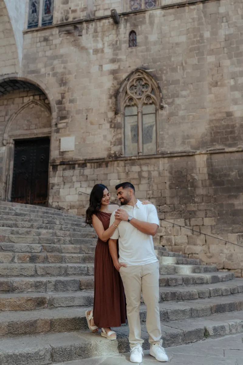 Couple shares a loving smile on historic stone steps during a couples & engagements photoshoot in the old city.