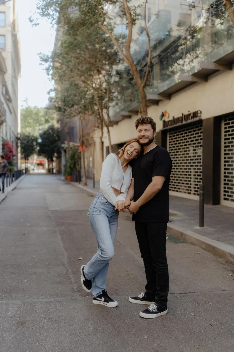 Couple shares a playful, affectionate moment on a quiet city street during a couples & engagements photoshoot.