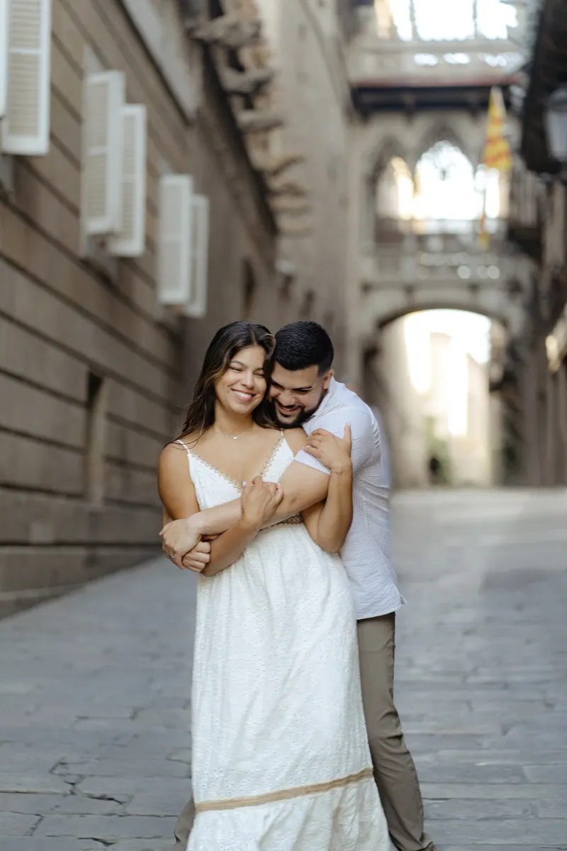 Couple shares a playful embrace on a historic city street during their couples & engagements photoshoot.