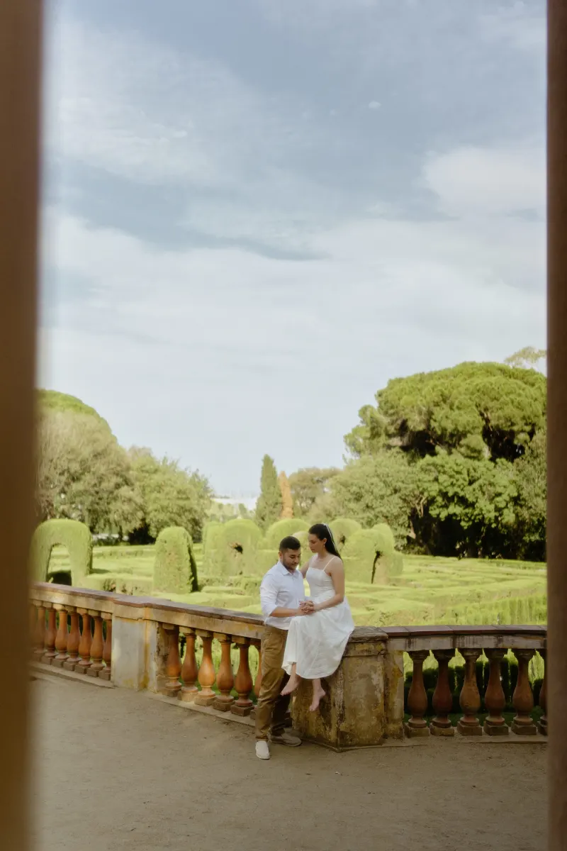 Couple shares a quiet, affectionate moment by a garden terrace during a couples & engagements photoshoot.