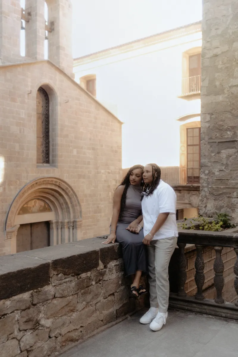 Couple shares a quiet, affectionate moment on a stone terrace during their surprise proposal photoshoot in Barcelona.
