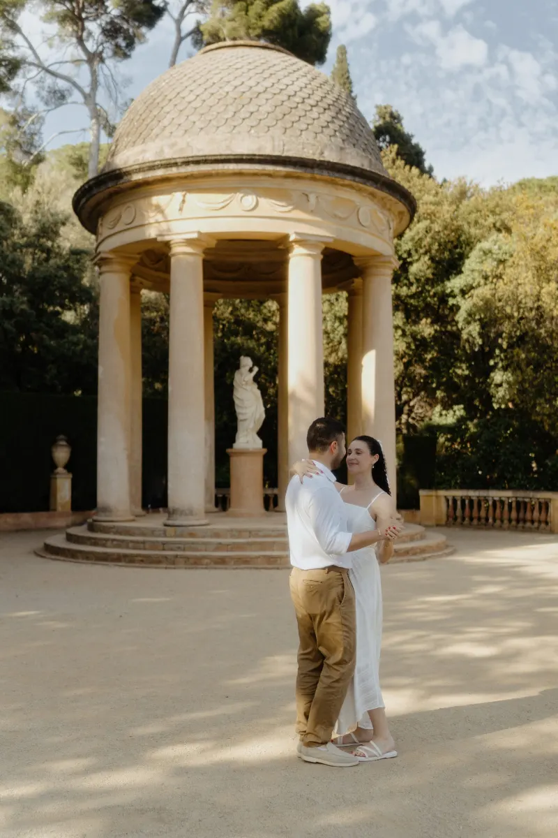 Couple shares a quiet dance in front of a classical pavilion, captured during a couples & engagements photoshoot.