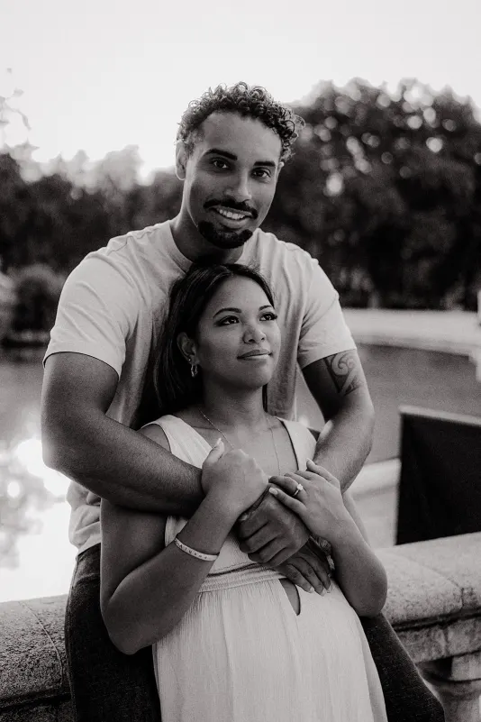 Couple shares a quiet embrace by the water, highlighting their connection during a couples & engagements photoshoot.