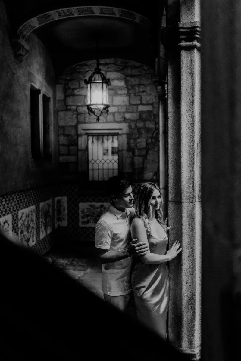 Couple shares a quiet embrace in a moody stone hallway during their Barcelona Vacation Portraits photoshoot.