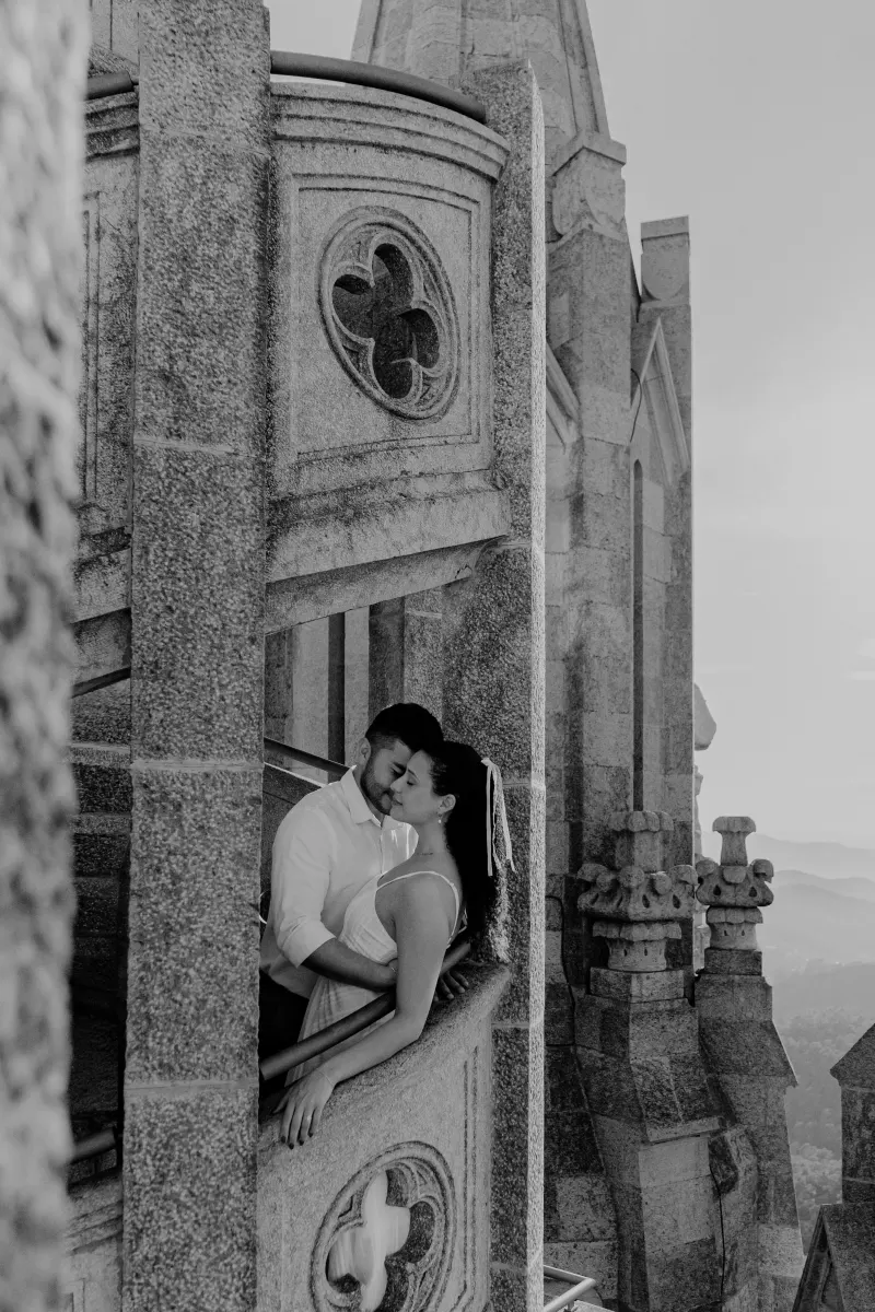 Couple shares a quiet embrace on a stone balcony of a historic building during their couples & engagements photoshoot.