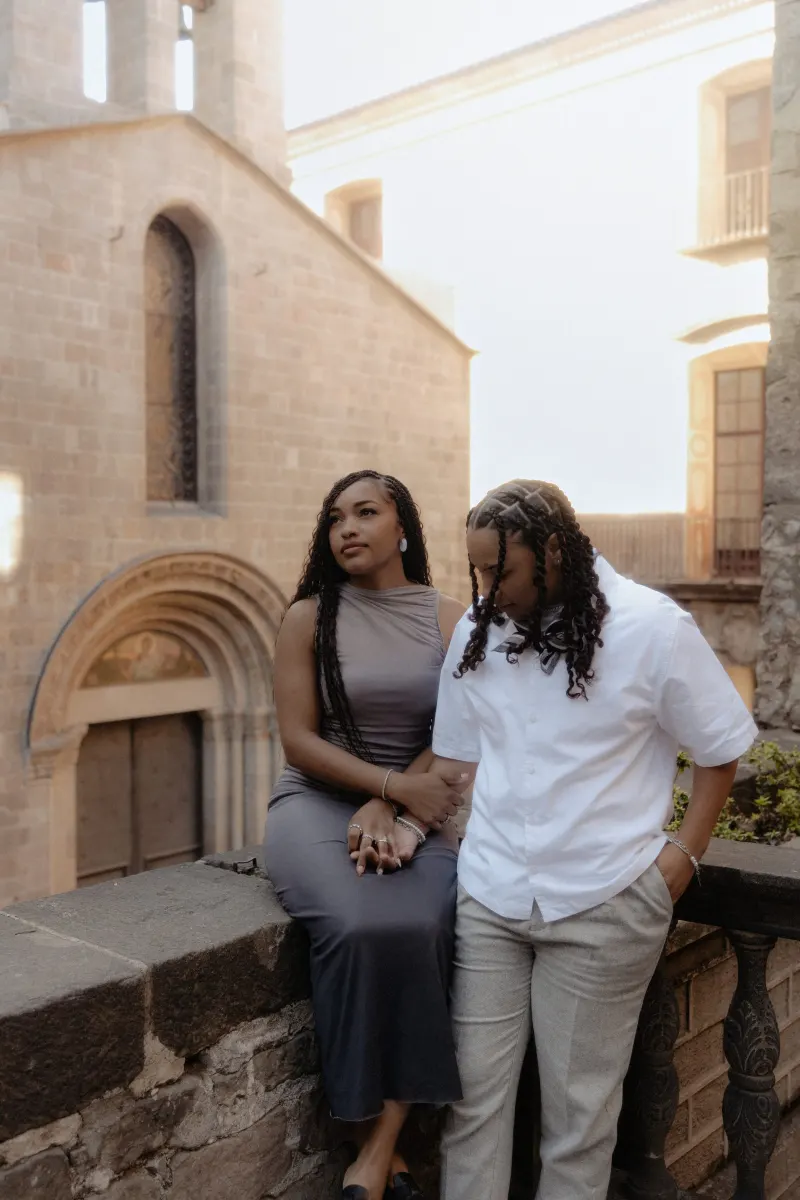 Couple shares a quiet, emotional moment on a stone terrace during their surprise proposal photoshoot in Barcelona.