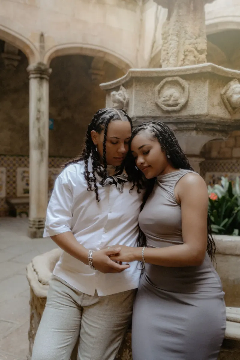 Couple shares a quiet, heartfelt embrace by a historic fountain during their surprise proposal photoshoot in Barcelona.