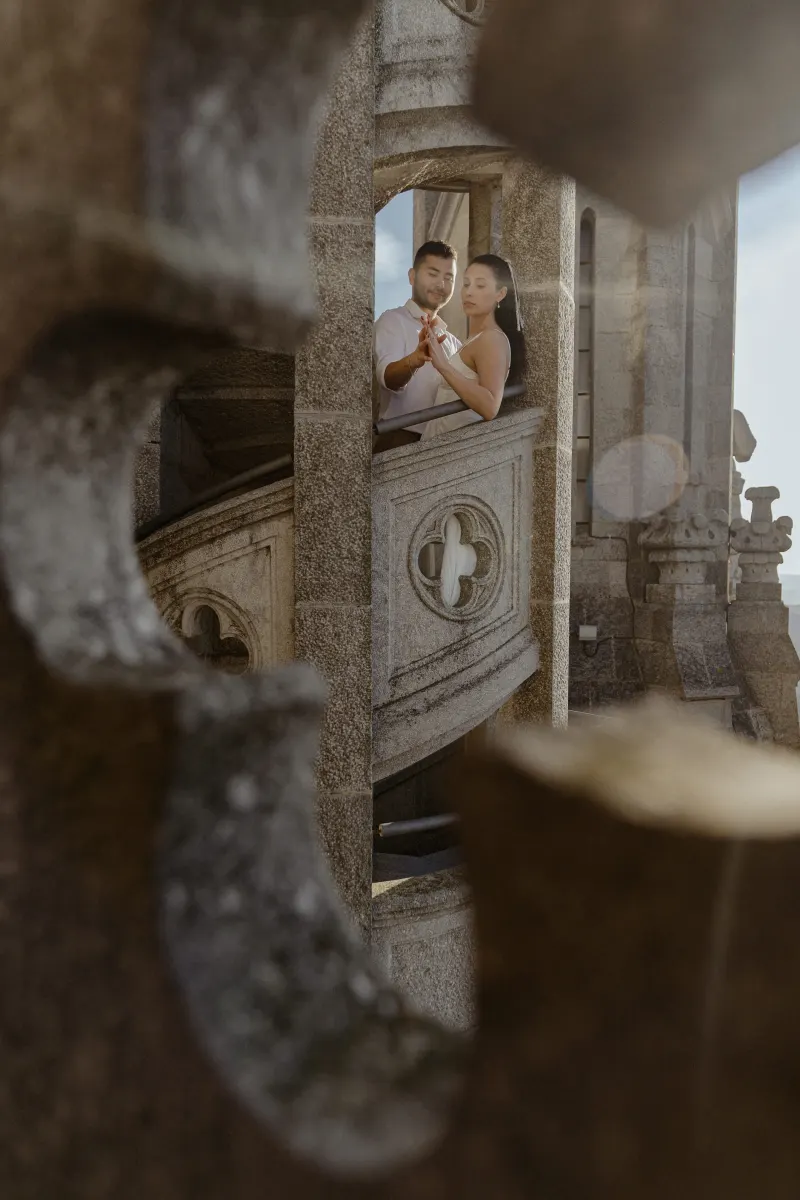 Couple shares a quiet, intimate moment on a stone balcony during a couples & engagements photoshoot at a historic landmark.