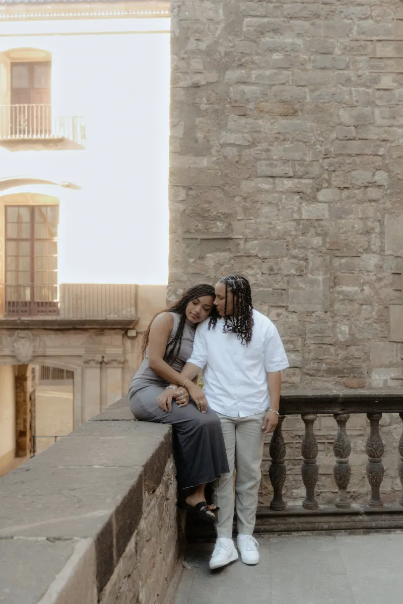 Couple shares a quiet, loving moment on a stone terrace in Barcelona during their surprise proposal photoshoot.