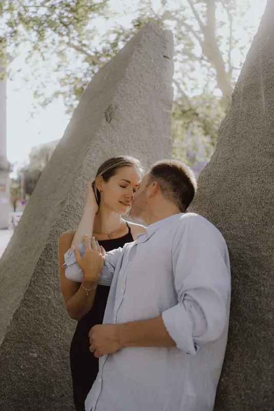 Couple shares a quiet, romantic moment between stone sculptures during a couples & engagements photoshoot outdoors.