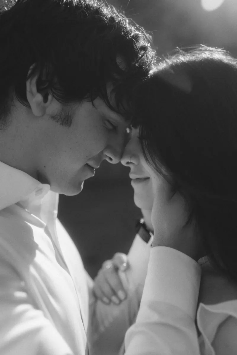 Couple shares a soft, intimate forehead touch, eyes closed and smiling during a couples & engagements photoshoot.