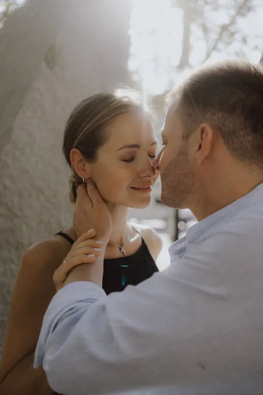 Couple shares a soft, loving moment in golden sunlight during an outdoor couples & engagements photoshoot.