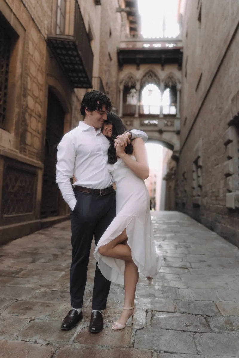 Couple shares a tender embrace on a cobblestone street in Barcelona’s Gothic Quarter during an engagement photoshoot.