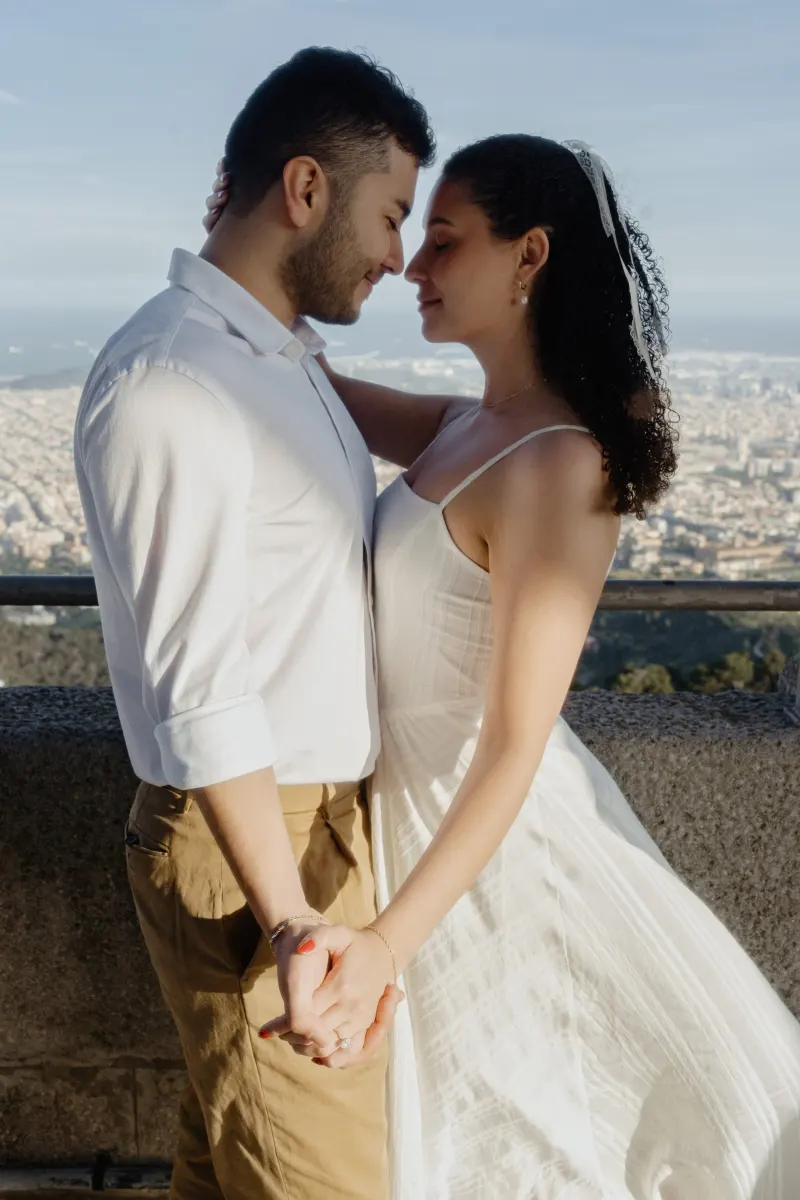Couple shares a tender embrace on a scenic overlook, holding hands during a romantic couples & engagements photoshoot.