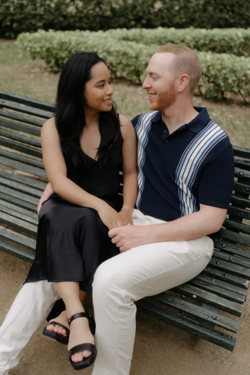 Couple shares a tender, joyful moment on a park bench during their surprise proposal photoshoot.