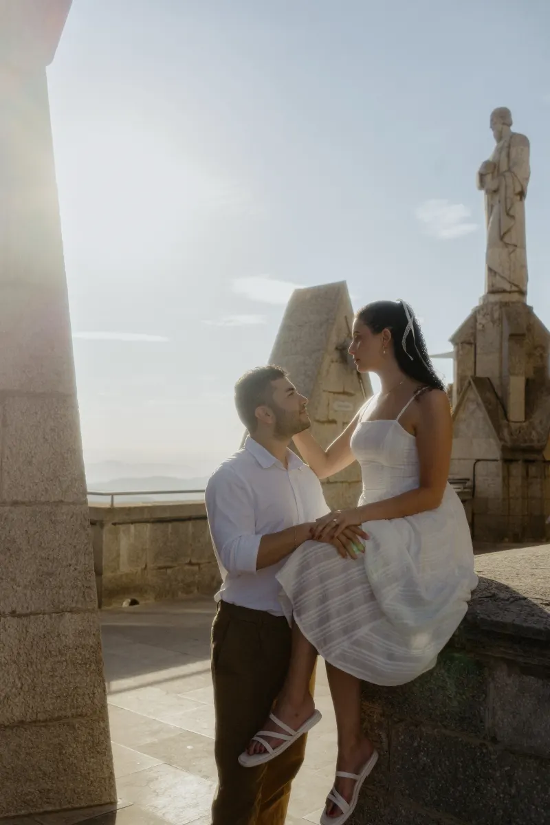 Couple shares a tender moment at a sunlit stone terrace, captured during a couples & engagements photoshoot.