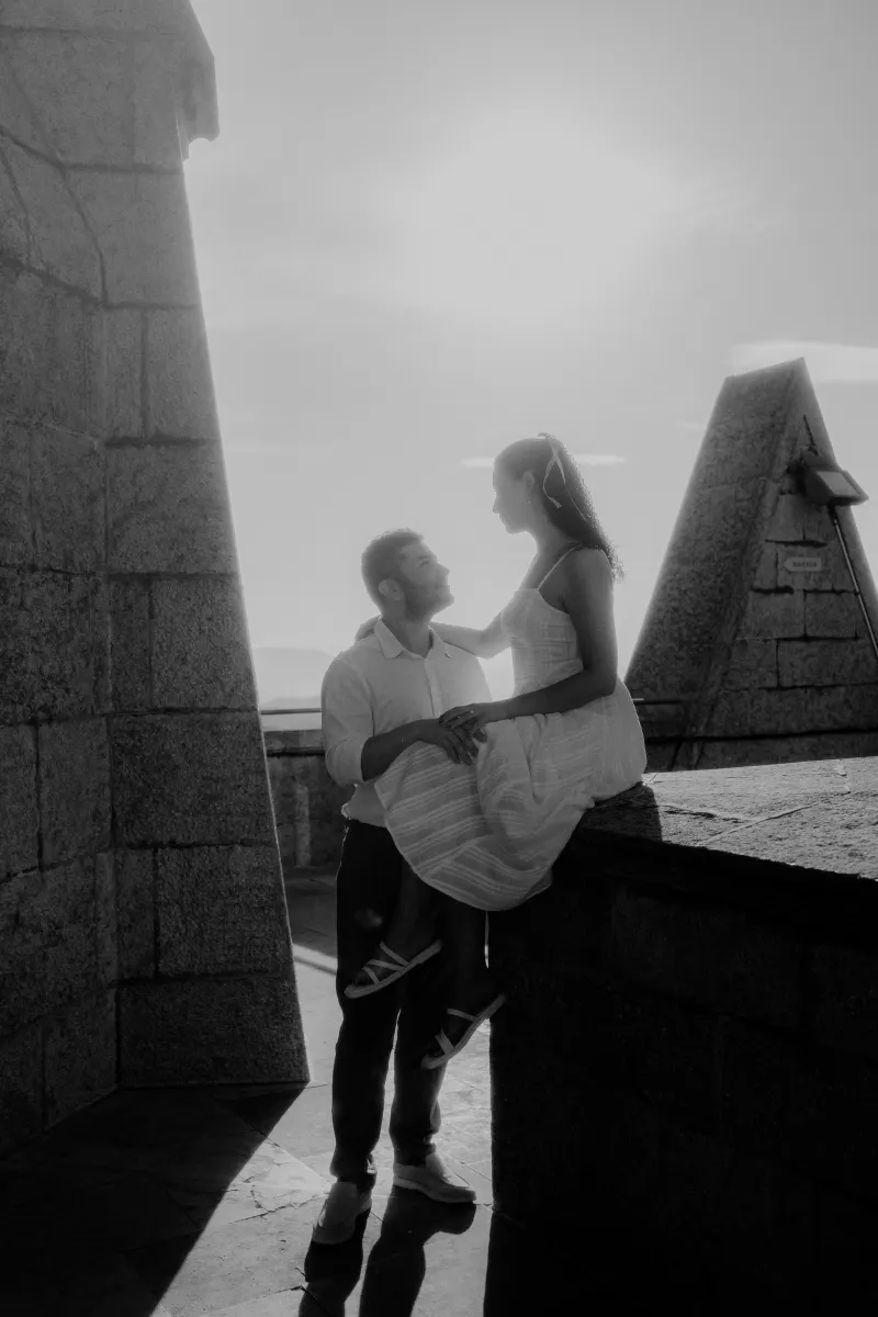 Couple shares a tender moment at sunset atop a stone terrace, captured during a couples & engagements photoshoot.