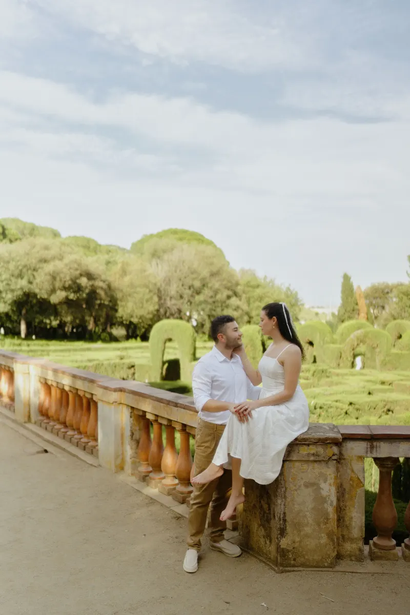 Couple shares a tender moment on a garden terrace, captured during a couples & engagements photoshoot.