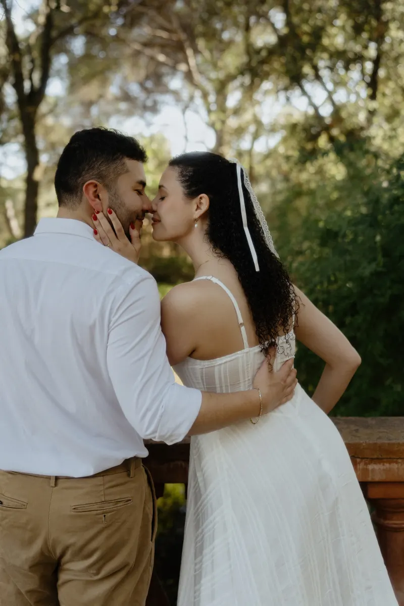 Couple shares a tender nose-to-nose moment on a garden terrace, captured during a couples & engagements photoshoot.