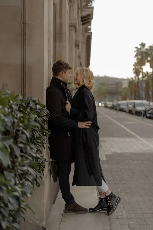 Couple shares a warm, loving gaze on a quiet Barcelona street during a couples & engagements photoshoot.