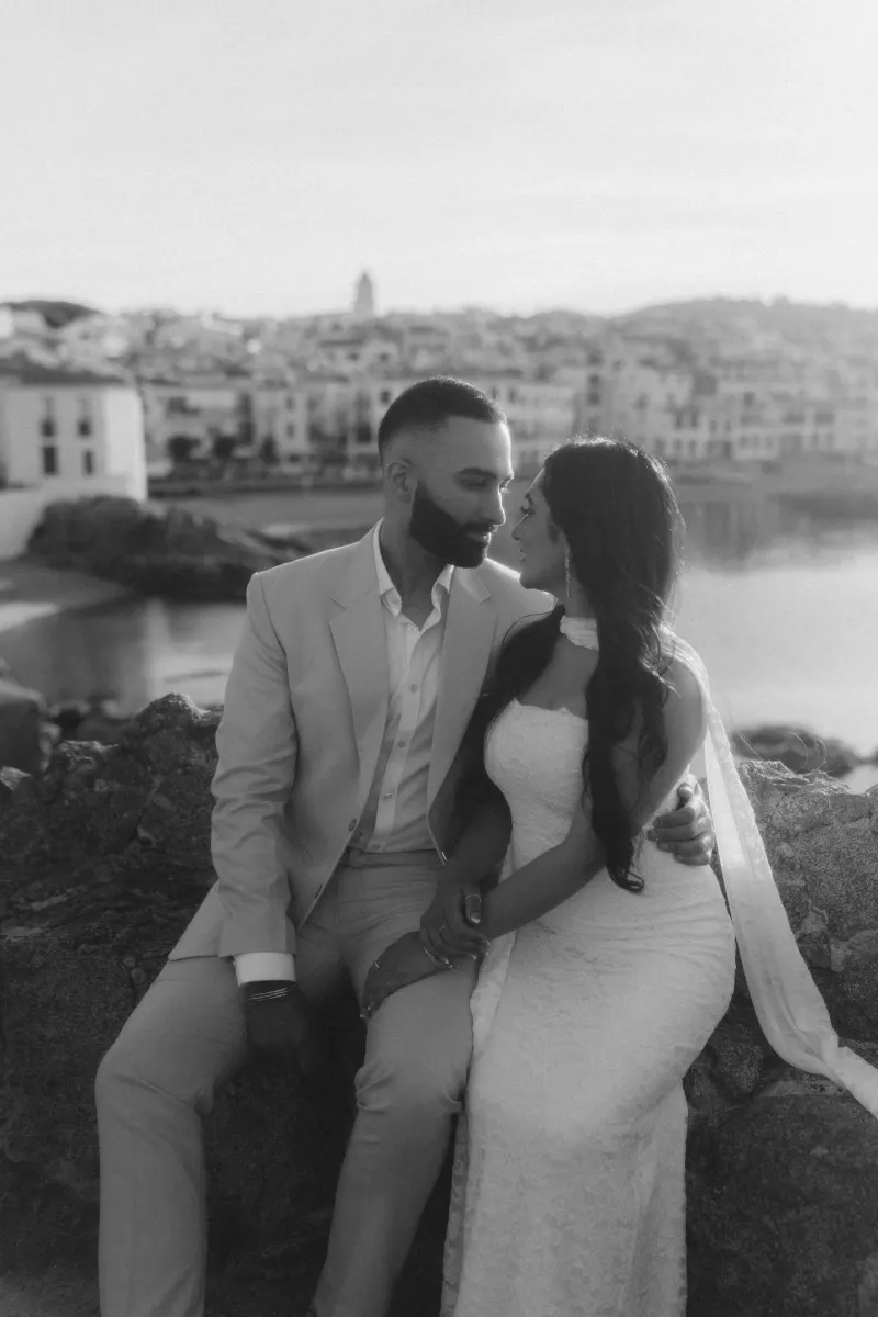 Couple shares an intimate moment during a surprise proposal photoshoot by the waterfront in a Mediterranean town.