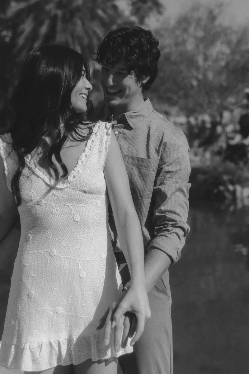 Couple sharing a joyful, intimate moment outdoors, holding hands and smiling during a couples & engagements photoshoot.