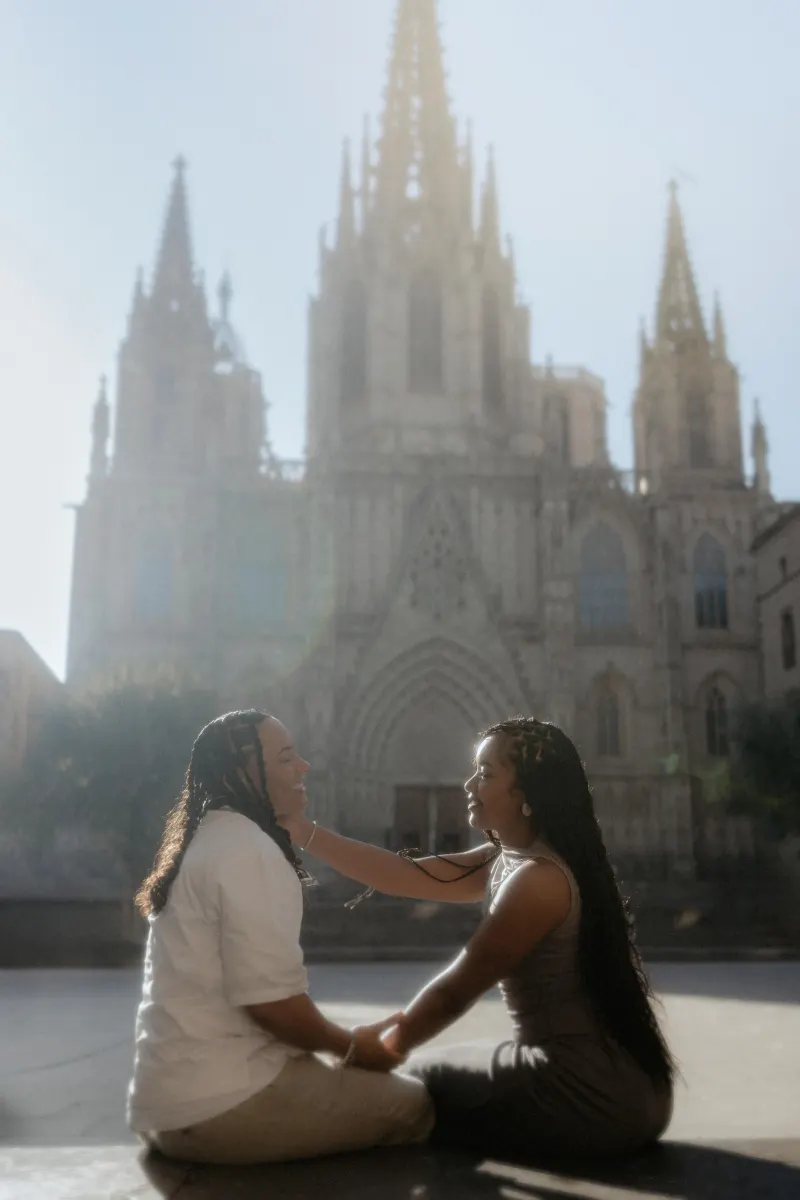 Couple sharing a joyful moment during a surprise proposal photoshoot in front of Barcelona Cathedral.
